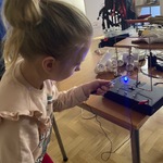 Dziewczynka sprawdza przepływ prądu w urządzeniu.jpeg